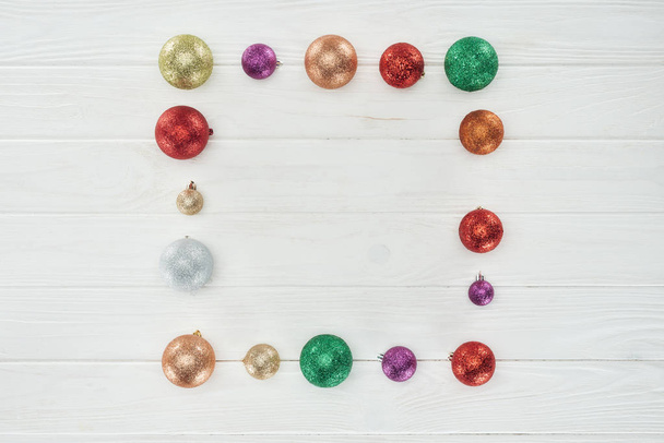 felülnézet, fényes színes karácsonyi labdák, fehér fa háttér - Fotó, kép