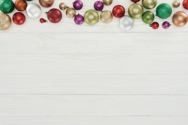 beautiful shiny colorful christmas balls on white wooden background  - Фото, изображение