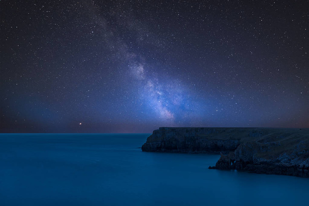 Εκπληκτική ζωντανή σύνθετη εικόνα του Milky Way πάνω από το τοπίο της Μπαραφούντλε Bay στη διαδρομή Μαραθωνίου Αθηνών ακτή στην Ουαλία - Φωτογραφία, εικόνα