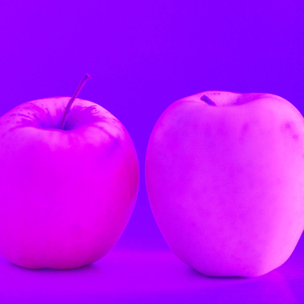 Deux pommes roses sur la table en lumière violette néon
 - Photo, image