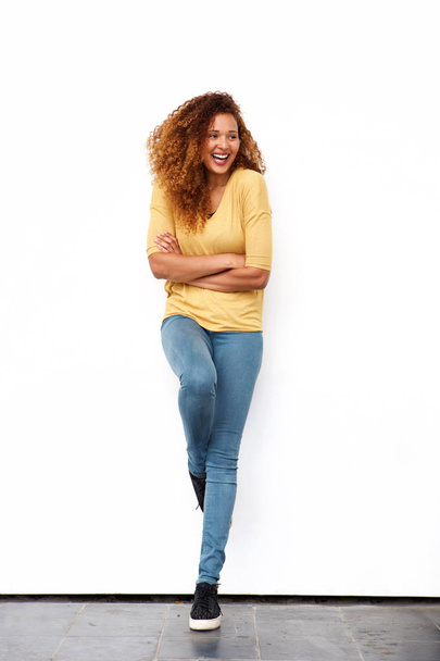 Full body portrait of beautiful young woman laughing against white wall - Photo, image
