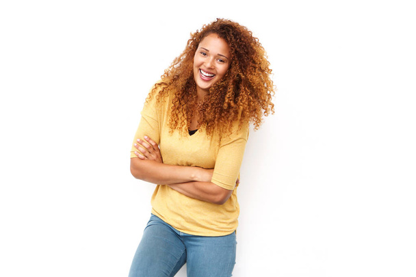 Portret van mooie jonge vrouw met krullend haar lachen met armen gekruist tegen witte achtergrond - Foto, afbeelding