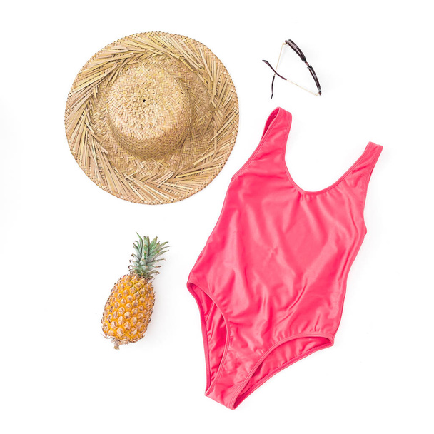 Muoti koostumus ananas hedelmiä, aurinkolasit, olki hattu ja vaaleanpunainen bikinit uimapuvut valkoisella pohjalla. Tasainen, ylhäältä
 - Valokuva, kuva