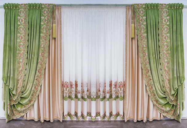Décoration de l'intérieur du salon dans le style classique palais. Rideaux en tissu de velours de soie vert avec ornement, et tulle avec broderie
 - Photo, image