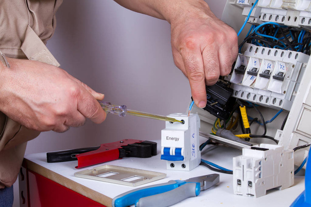 electricista fijación de dispositivos eléctricos con diferentes herramientas
 - Foto, imagen