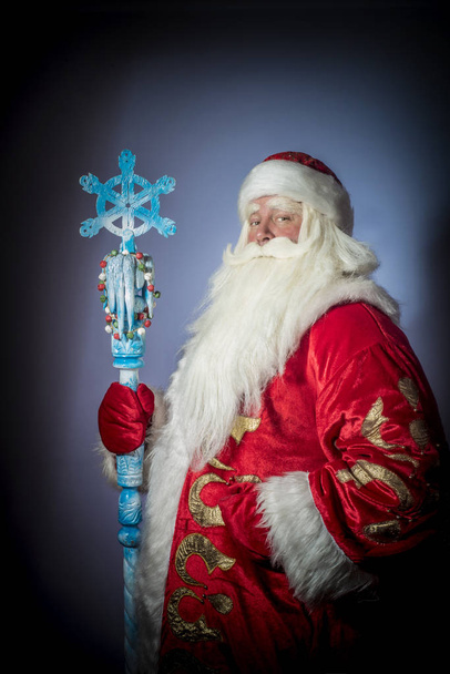 A traditional Christmas Santa Clause with staff on blue background - Fotoğraf, Görsel