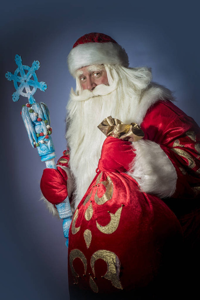 A traditional Christmas Santa Clause with staff on blue background - Foto, Bild