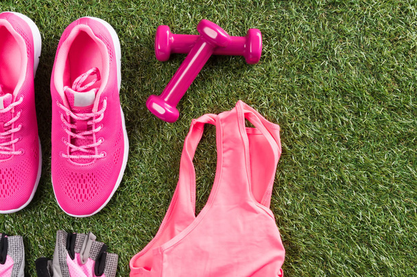 on a green lawn, a set of women's sports things pink color - Foto, Imagem