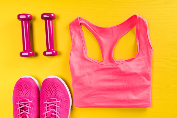 on a yellow background, a set of women's sports things of pink color - Foto, Bild