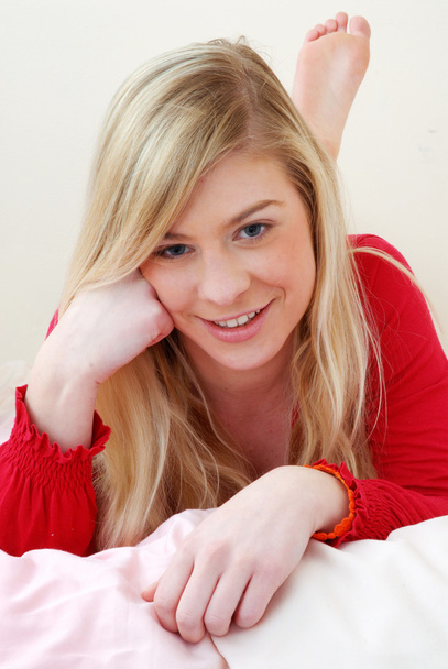 Beautiful young woman portrait lying down on bed. - Zdjęcie, obraz