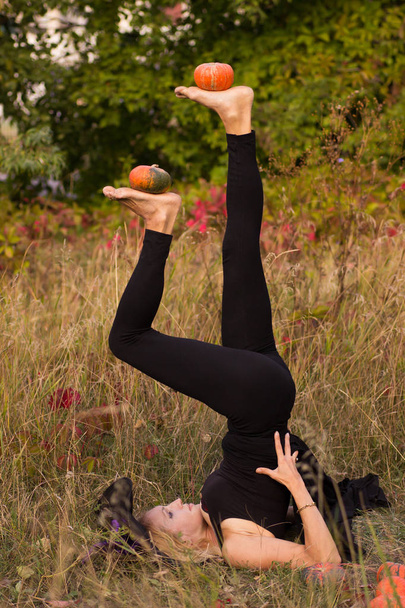 İçinde kabak ile yoga pozisyonlarda ellerini pratik Halloween kılık kız - Fotoğraf, Görsel
