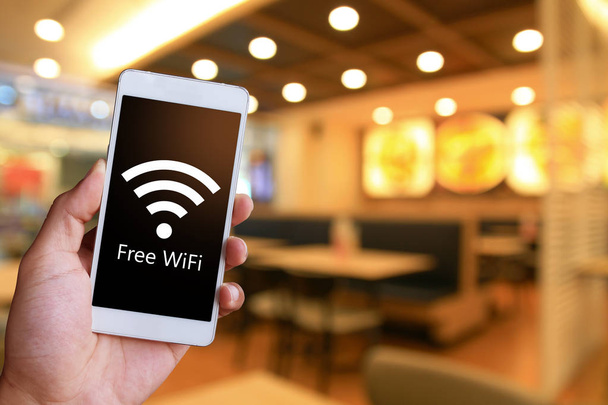 Man è in possesso di uno smartphone generico bianco che mostra il WiFi gratuito. Connessione al punto di accesso pubblico
. - Foto, immagini