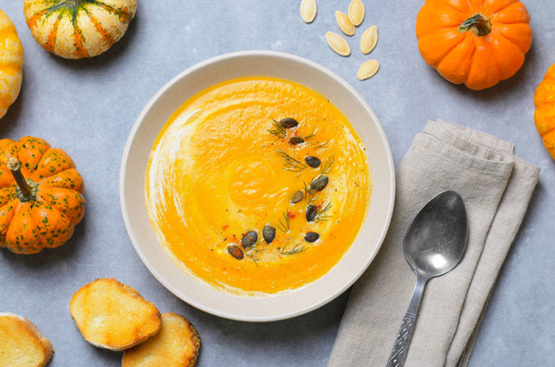 Тыквенный суп со сливками, укропом и тыквенными семенами, вкусная еда, вид сверху
 - Фото, изображение
