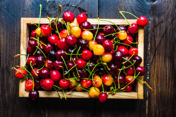 Fresh organic sweet cherries in wooden box with copy space - Foto, Imagem