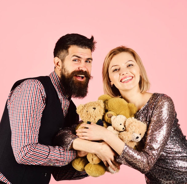 Couple in love holds heap of teddy bears on pink - Photo, Image