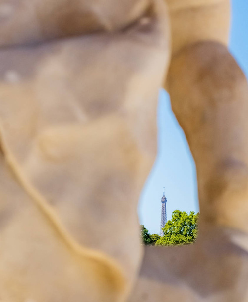 Näkymä Eiffel-tornin Luxemburgin puutarhassa sijaitsevan patsaan läpi etäisyydellä
 - Valokuva, kuva