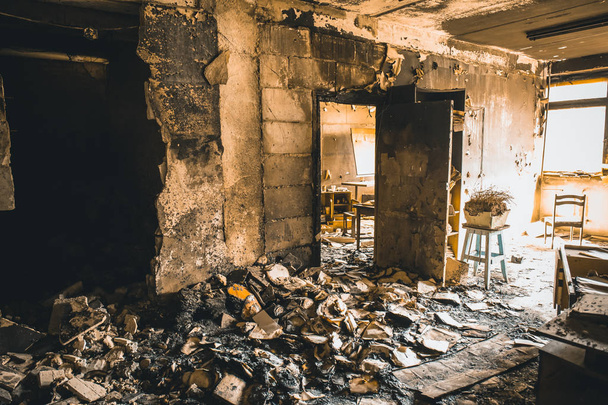 Burned house interior after fire, ruined building room inside, disaster or war aftermath concept, toned - Photo, Image