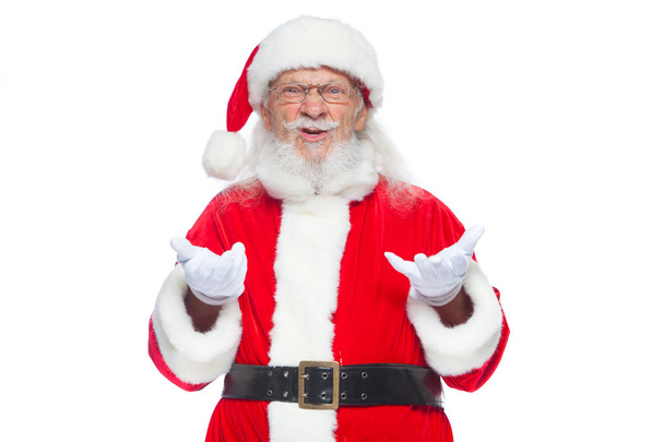 Weihnachten. Der gute Weihnachtsmann in weißen Handschuhen zeigt Gesichter, Fratzen, zeigt seine Zunge. nicht das Standardverhalten. isoliert auf weißem Hintergrund. - Foto, Bild
