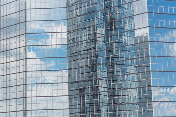 雲とミラーの建物は、近代的なオフィスのワークスペースのウィンドウに反映されます。ガラス高層商業ビル、未来の都市の鋼の明るい青の背景 - 写真・画像