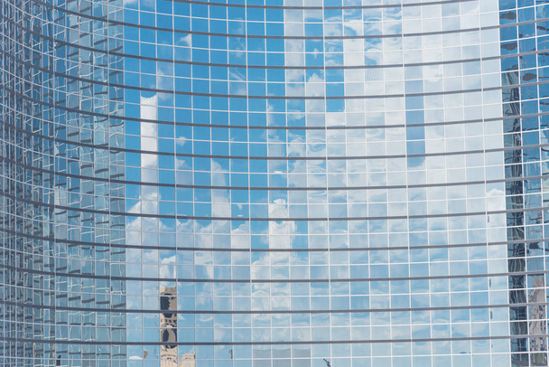 雲とミラーの建物は、近代的なオフィスのワークスペースのウィンドウに反映されます。ガラス高層商業ビル、未来の都市の鋼の明るい青の背景 - 写真・画像
