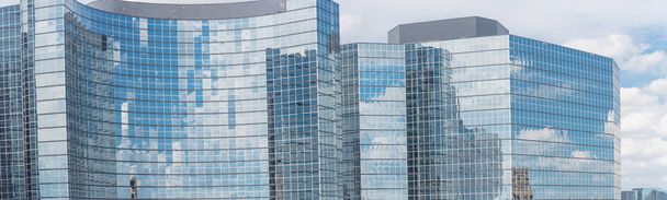Panorama view glass building facade background, blue cloud sky reflected in modern mirror glass wall. Business concept of success industry tech architecture detail background - Fotografie, Obrázek
