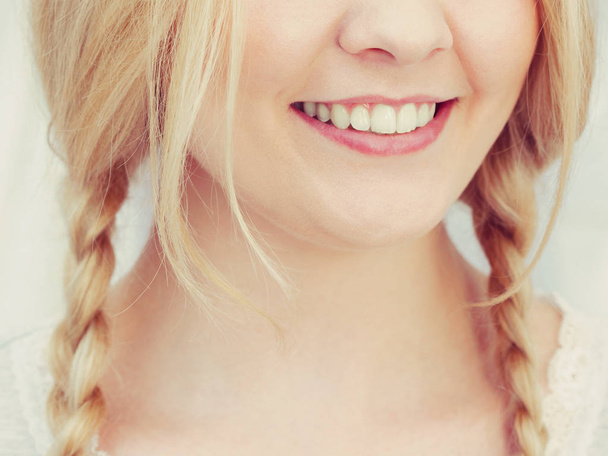 Happy funny woman having long blonde hair in two braided hairstyle. Haircare concept. - Φωτογραφία, εικόνα