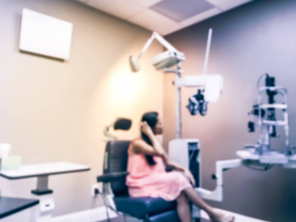 Mujer asiática abstracta borrosa paciente a la vista y especialistas en láser a la espera de su examen óptico
 - Foto, Imagen