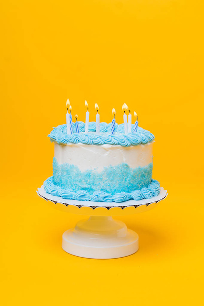 Παγωμένο άσπρο κέικ με μπλε διακόσμηση και κεριά - Φωτογραφία, εικόνα