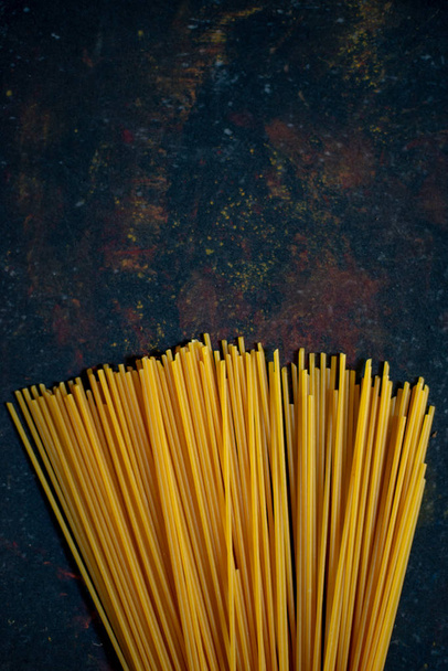 Spaghetti gialli su sfondo nero - Foto, immagini
