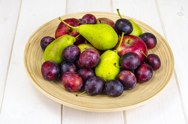 Ripe fruit on wooden plate - Photo, Image