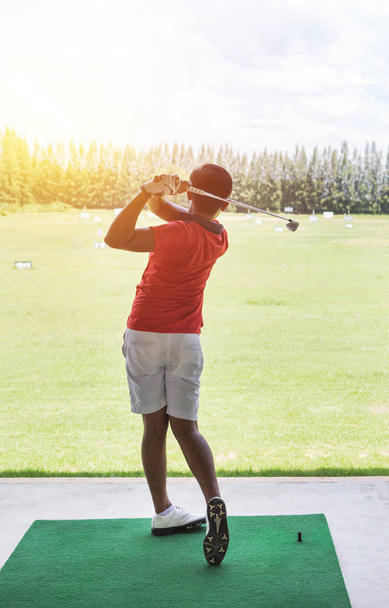 jeune golfeur en action frapper le tir de golf pendant la pratique de conduite dans les panneaux de cour de golf
 - Photo, image