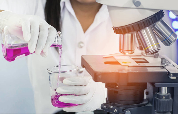 bilim adamı kadın araştırma Kimya sıvı ile mikroskop ekipmanların araştırma deneyler için yakın bilim laboratuvarı deney tüpü - Fotoğraf, Görsel