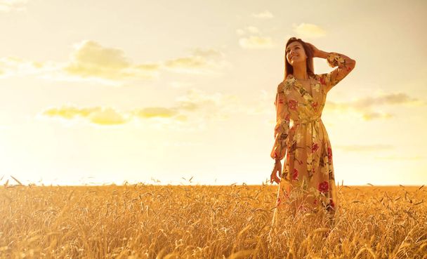 Young girl in wheat field at sunset - Фото, зображення