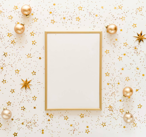Christmas background from gold and white Christmas decorations and frame mock up  . Xmas composition of New Year's Christmas balls. Winter holiday concept.Flat lay. Top view. Copy space - Фото, изображение