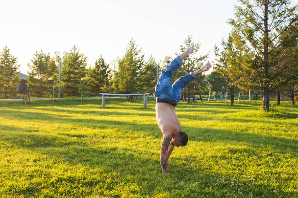 Jóga, fitness a zdravého životního stylu koncepce - člověk dělá stojka na letní přírody - Fotografie, Obrázek