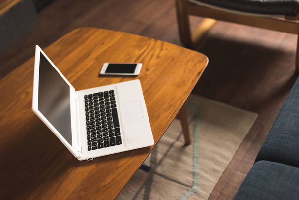 Laptop und Smartphone auf dem Tisch mit niemandem, Konzept der Arbeit zu Hause - Foto, Bild