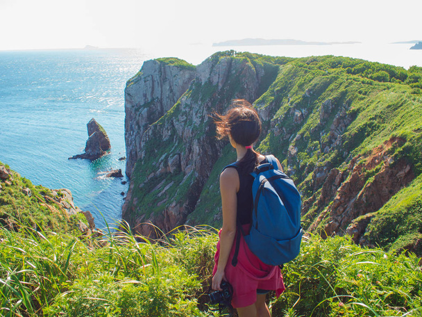 mladá žena stojí sám na skalnatém útesu, dívka turistické fotograf na pozadí krásných přírodních - Fotografie, Obrázek