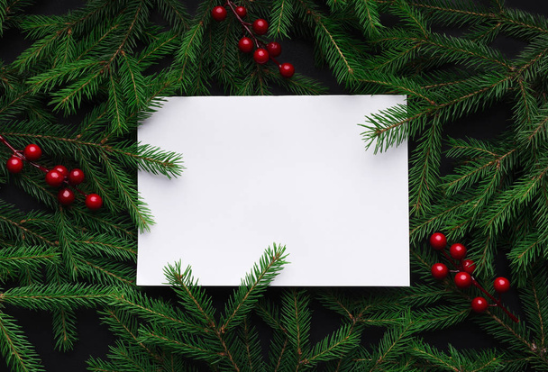 Fenyő fa ágai díszített vörös karácsonyi bogyók, mint határon fehér üres papírra, másol hely - Fotó, kép