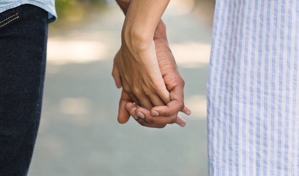 African-american couple holding hands while walking in park - Photo, Image