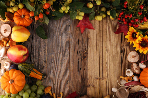 Autumn nature concept. Fall fruit and vegetables on wood. Thanksgiving dinner. Corn and pumpkin with sunflowers and plums - Foto, imagen