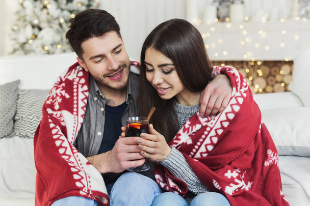 冬の夜に暖かいワインのグラスとリラックスしたカップル - 写真・画像