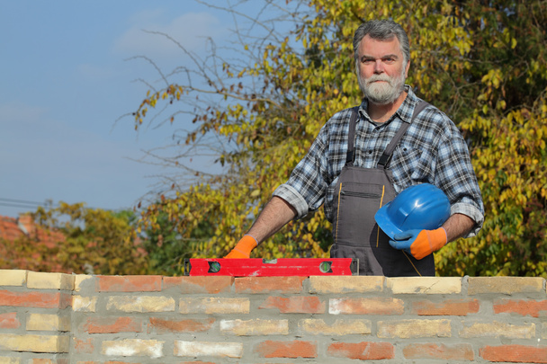 Worker control brick wall using level tool, real people, no retouch - Photo, Image