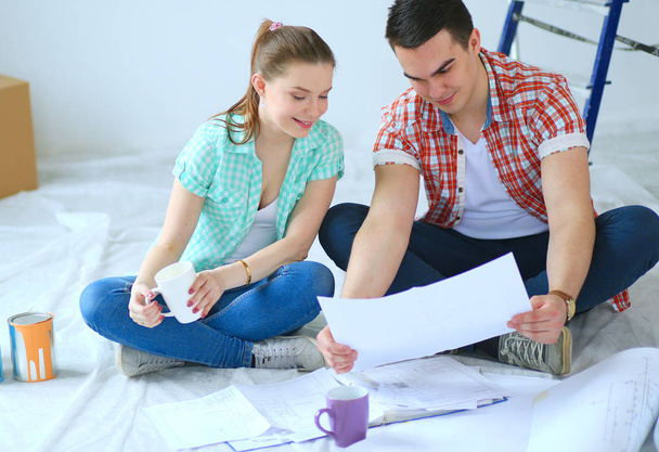 Young couple sitting on floor and calculating about they savings. Young couple - Foto, imagen