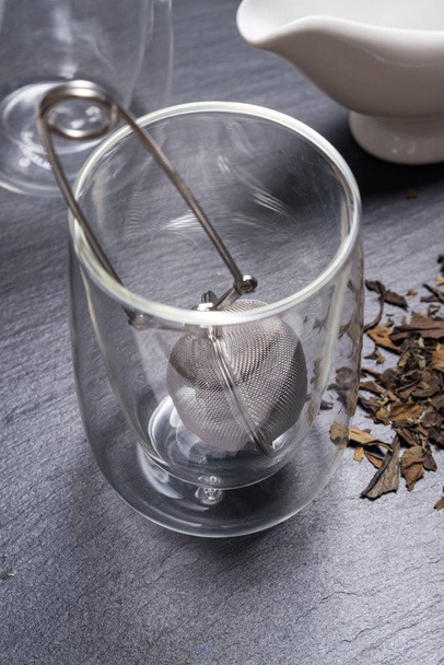 Double walled glass with tea and stainless steel tea infuser - 写真・画像