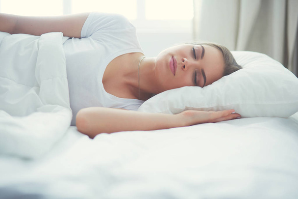 Beautiful young blonde woman sleeping in bed - Фото, зображення