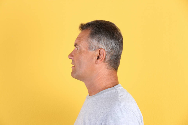 Mature man with hearing problem on white background - Foto, afbeelding