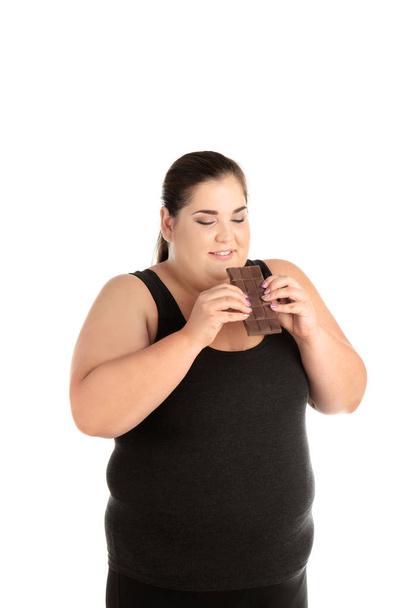 Overweight woman with chocolate bar on white background - Фото, зображення