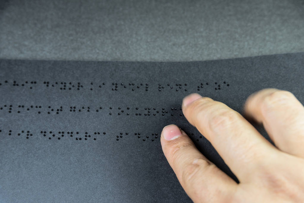 Widok z góry ręki osoby niewidomej czytanie książki napisane w alfabecie Braille'a dla osób niewidomych. Kopiować miejsca do edycji. Istanbul,Turkey.10 luty 2017 - Zdjęcie, obraz