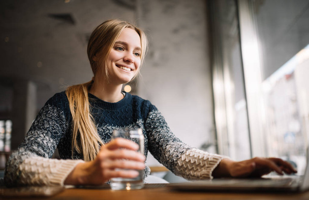 Portré, fiatal mosolygó nő ül a tetőtéri kávézó laptop számítógép és internet, gépelés-ra billentyűzet, kutatásával információk segítségével. Vonzó szabadúszó szövegíró a munka. Sikeres üzleti.  - Fotó, kép