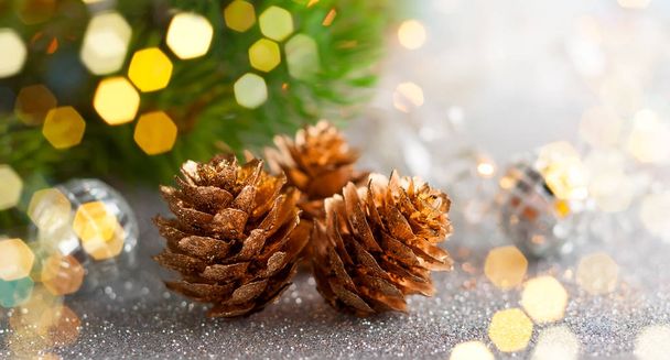 Christmas concept with silver bauble, fir cones and festive fir tree - Photo, image